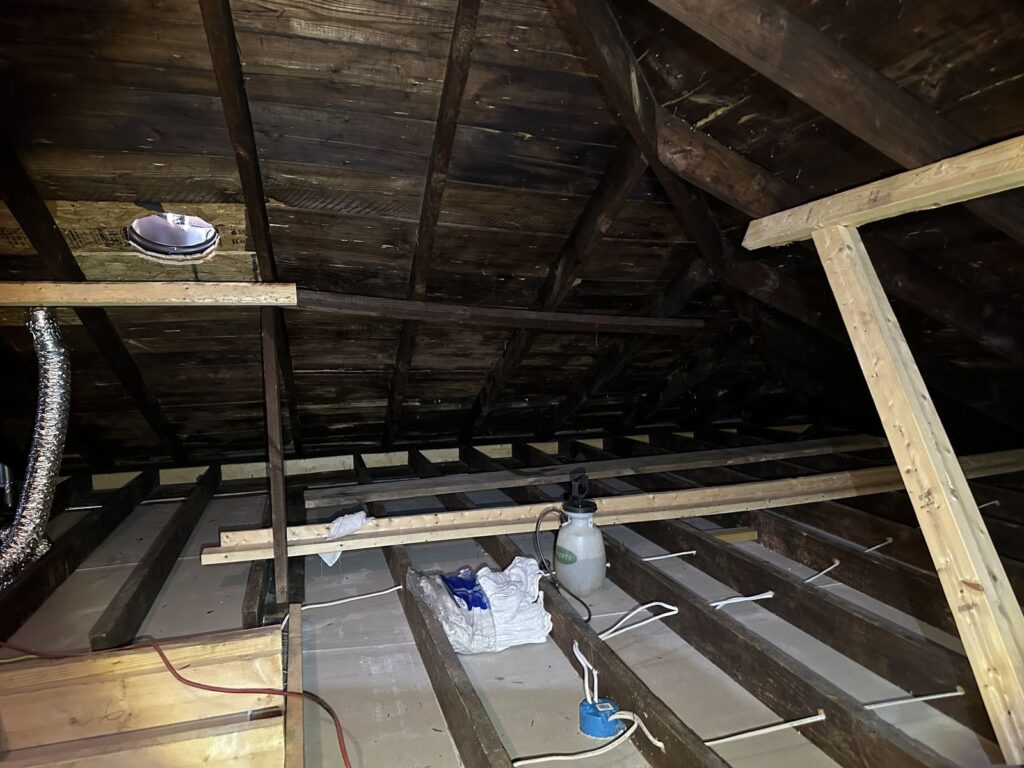 Mold remediation in progress in an attic with containment and equipment