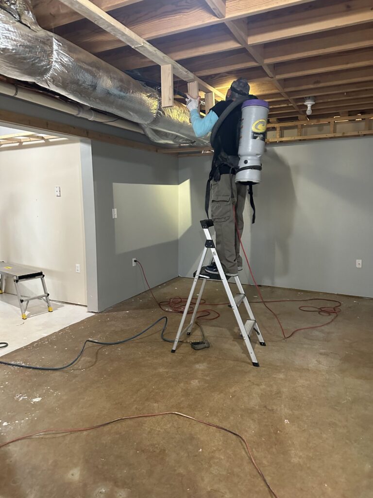 Mold remediation technician treating an overhead area during a remediation job