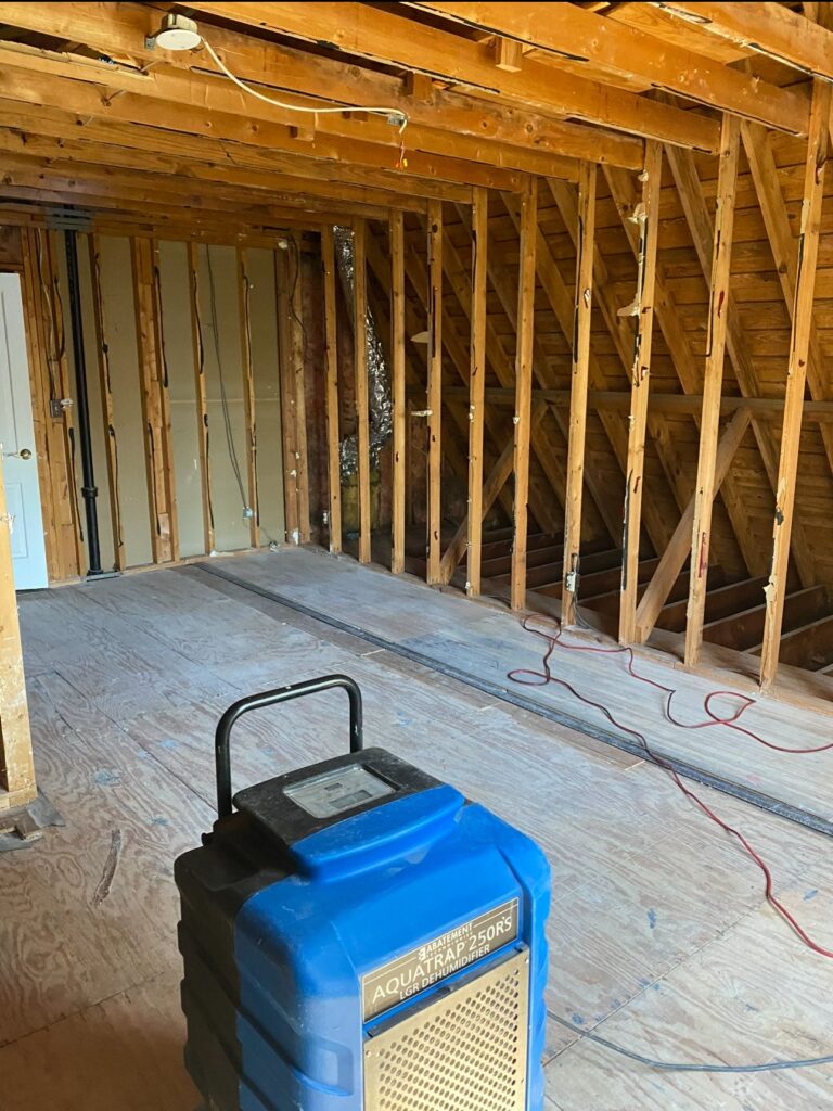 Water damage restoration drying equipment set up in a property stripped to the studs by Property Restoration Pros